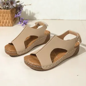 Gedetailleerd aanzicht van beige ademende sleehaksandalen met uitgesneden patroon.
