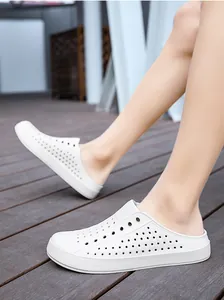 Detailed close-up of white breathable outdoor clogs being worn on a wooden deck.