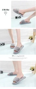 Detailed view of cozy gray faux fur open-toe slippers worn by a model in a modern home setting.