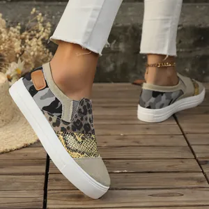 Detail view of women's casual canvas loafers with leopard and snakeskin pattern mix.