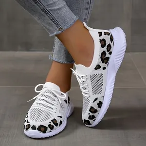 Close-up of white mesh sneakers featuring a stylish leopard print and lace-up design
