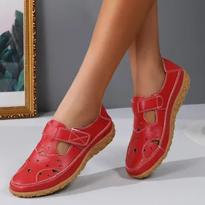 Detailed side view of stylish red hollow-out leather flat sandals for women on model