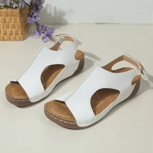 Detail van witte zomerse sleehaksandalen met ademende uitsparingen en klittenbandsluiting