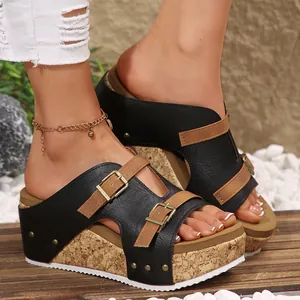 Κομψά γυναικεία σανδάλια με πλατφόρμα σε μαύρο και καφέ με διακοσμητικές αγκράφες σε μοντέλο