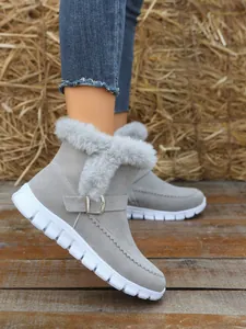 Bottines d'hiver grises élégantes avec bordure en fausse fourrure et boucle sur un modèle