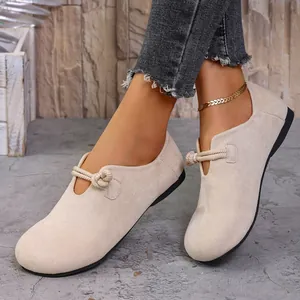 Vista detallada de mocasines de ante beige con detalle de cuerda anudada en pies