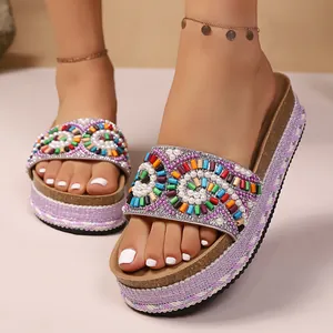 Vista detallada de bordados con cuentas de colores en sandalias étnicas de cuña