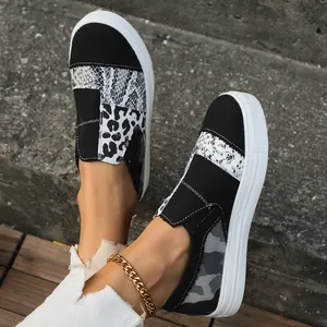 Close-up detail of stylish patchwork canvas loafers with snake and leopard print patterns