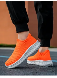 Close-up detail of bright orange slip-on flying woven knit sneakers for outdoor sports