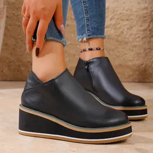Vue latérale de bottines compensées noires pour femmes avec fermeture éclair
