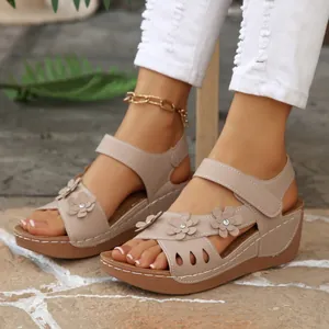 Retro-Keilsandalen für Damen mit ausgeschnittenen Blumendetails und Plateausohle.