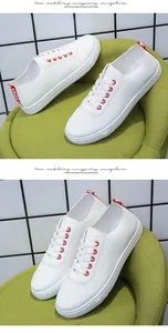Κοντινή λεπτομέρεια από λευκά δερμάτινα sneakers με κόκκινες οπές και αντίθετη λαβή φτέρνας