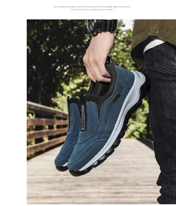 Detailed view of blue suede slip-on outdoor walking shoes held by a person outdoors