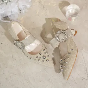Nahaufnahme von spitzen Denim-Pumps mit Strass-Schnalle und silbernen Nietendetails