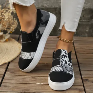 Detail view of women's patterned canvas sneakers with snakeskin and leopard prints.