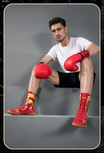 Chaussures de boxe professionnelles rouges et dorées portées par un mannequin de sport.