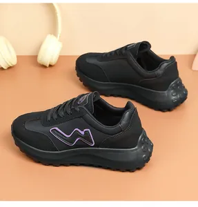 Close-up of black casual running shoes with chunky soles and purple wavy logo detail.