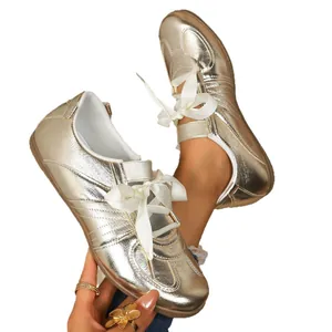 Elegante flache Damen-Sneaker in Gold-Metallic mit stilvollen weißen Bandschnürsenkeln.