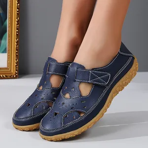 Detailed close-up of navy blue hollow-out flat sandals for women with durable gum sole