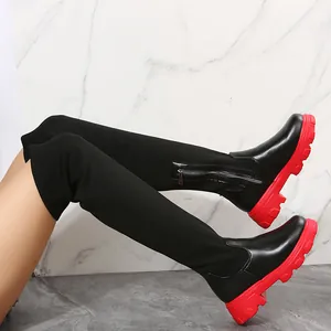 Close-up side view of over-the-knee boots with fly-knit upper and red platform sole