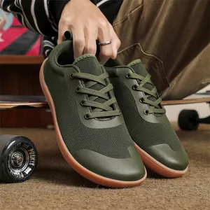 Close-up of olive green breathable flyknit upper and gum sole of barefoot sneakers.