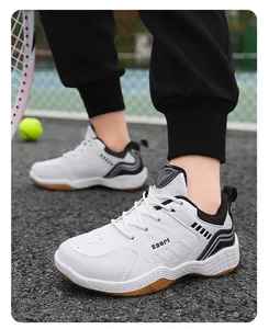 Gros plan de chaussures de sport blanches pour enfants portées sur un terrain de tennis