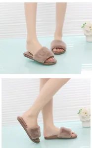 Detailed view of cozy faux fur open-toe slippers worn by a model on a blue surface