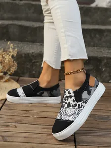 Close-up detail of women's patchwork canvas loafers featuring leopard and snake skin prints