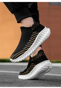 Lightweight black flyknit slip-on sneakers with gold stripes and white wavy soles