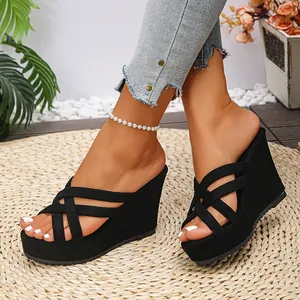 Close-up of stylish black wedge platform sandals on a rustic straw mat background