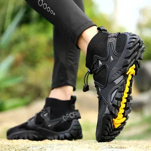 Close-up action shot of black outdoor wading shoes featuring a non-slip yellow tread design
