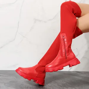 Side view showing red over-the-knee boots with knit texture and thick lug sole