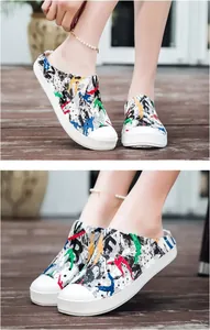Close-up of lightweight garden clogs with colorful graffiti print and a durable white sole.