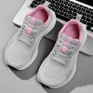 Modern grey and pink flyknit mesh running shoes for women displayed next to a laptop