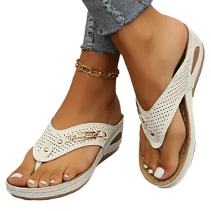 Sandales compensées blanches pour femmes avec détails perforés et décorations en strass.