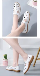 Close-up of white leather hollow-out sandals with soft textured soles for women.