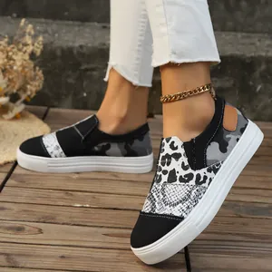 Detailed view of women's leopard and snake print canvas loafers with thick white soles