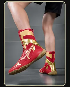 Vue détaillée de chaussures de lutte montantes rouge et or avec semelles en caoutchouc.