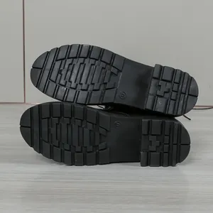 Gros plan des semelles en caoutchouc antidérapantes pour bottes noires, taille 37.