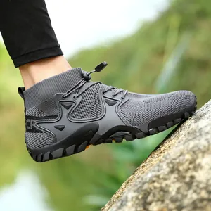 Detailed side view of breathable mid-top hiking wading shoe on natural rocky ground