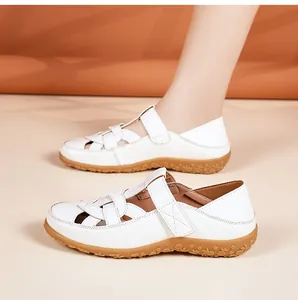 Side view detail of white hollow-out leather flat sandals with comfortable soft soles.