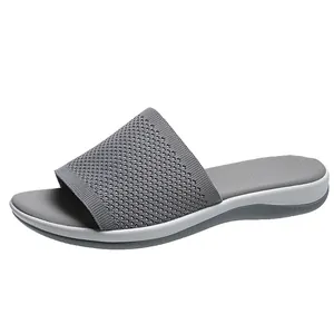 Side view profile of a grey flyknit women's slide sandal with soft cushioned sole