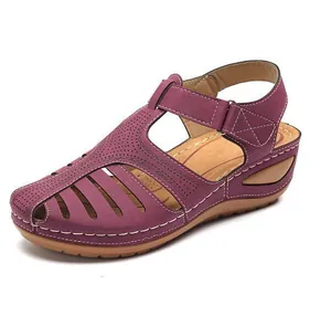 Detailed view of purple vintage closed-toe wedge sandals with hollow cutouts and stitching