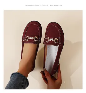Top view of wine red suede loafers featuring gold buckle detail and white stitching