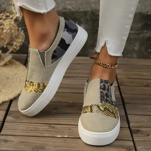 Close-up of women's mixed pattern canvas loafers with snake and leopard prints
