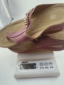 Pink wedge platform flip-flop being weighed on a digital scale showing 224.6 grams