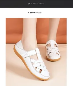 Close-up detail of stylish white hollow-out women's flat sandals on model's feet