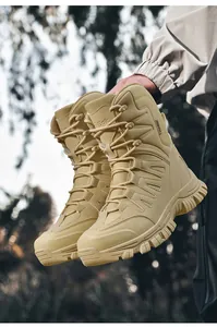 Détail de bottes de randonnée tactiques couleur sable tenues en plein air.