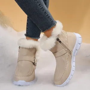 Gros plan de bottines d'hiver beige avec bordure en fausse fourrure blanche et fermeture