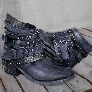 Detailed macro view of vintage distressed leather boots with punk rivets and buckles